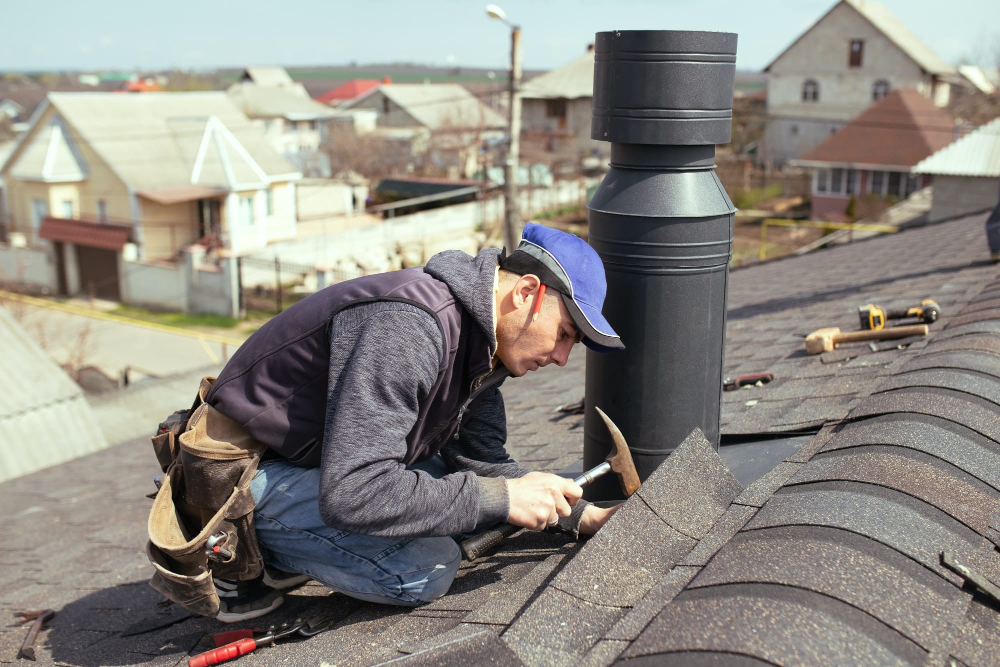 a professional master (roofer) with hammer repairs the roof.